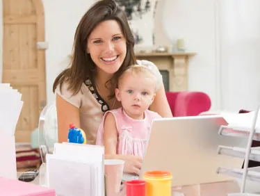 Mother and baby in home office with laptop