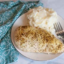 lemon pepper seasoning on chicken breast on white plate