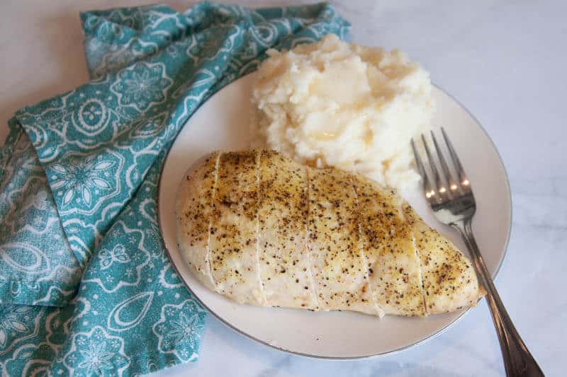 lemon pepper seasoning on chicken breast on white plate