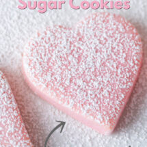 Pink heart shape cookie, sprinkled with powdered sugar. Text overlay says Valentine Sugar Cookies - Easy to Make