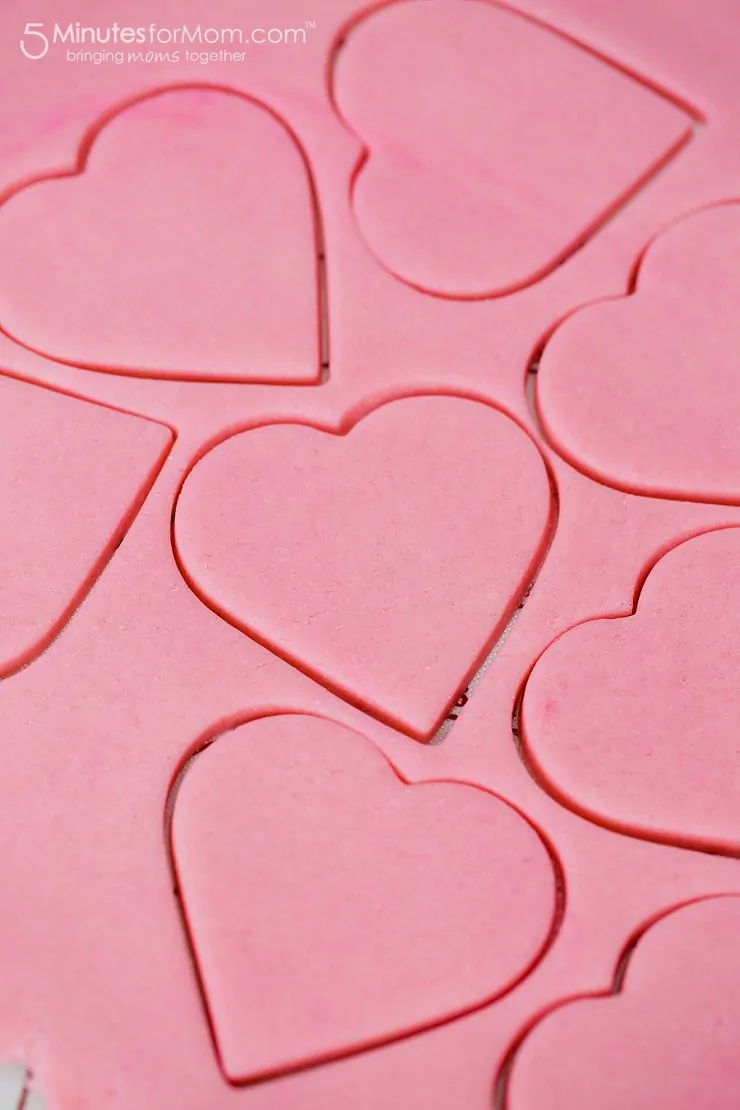 Pink cookie dough with heart shaped cut-outs to make fast and easy valentines day cookies