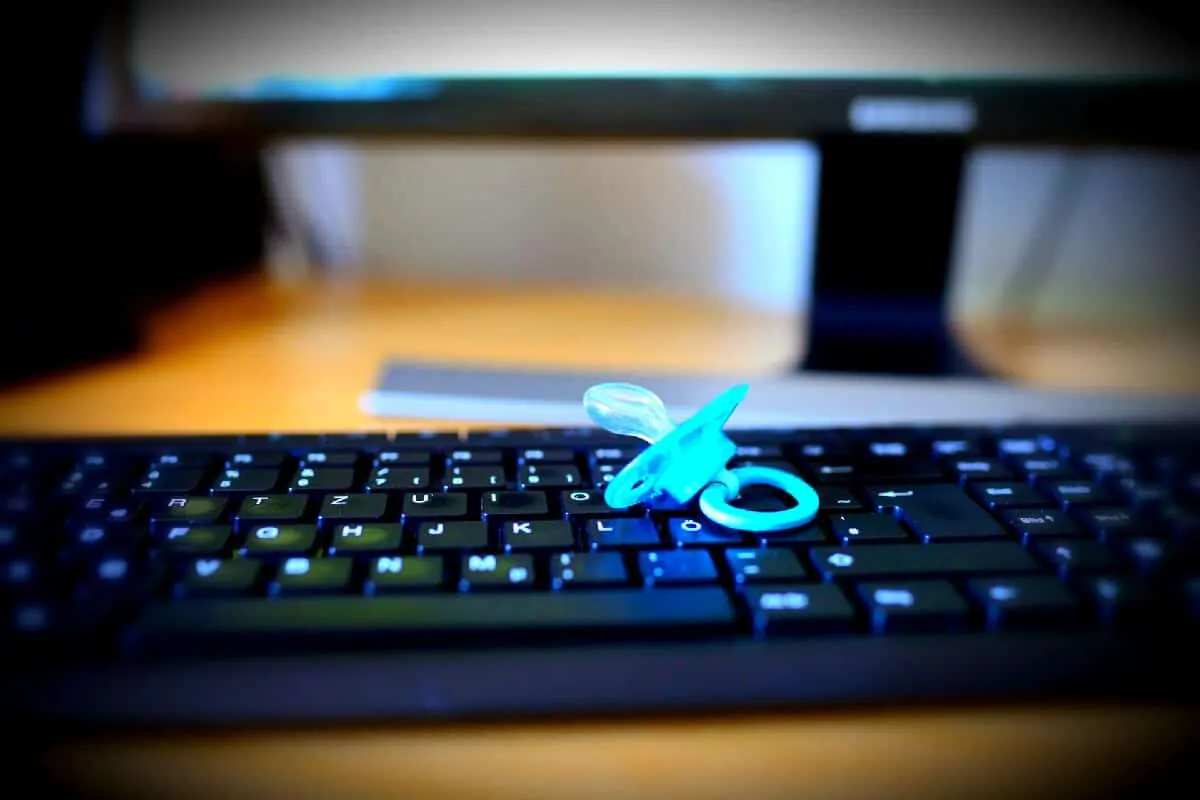 child's pacifier on mother's keyboard 