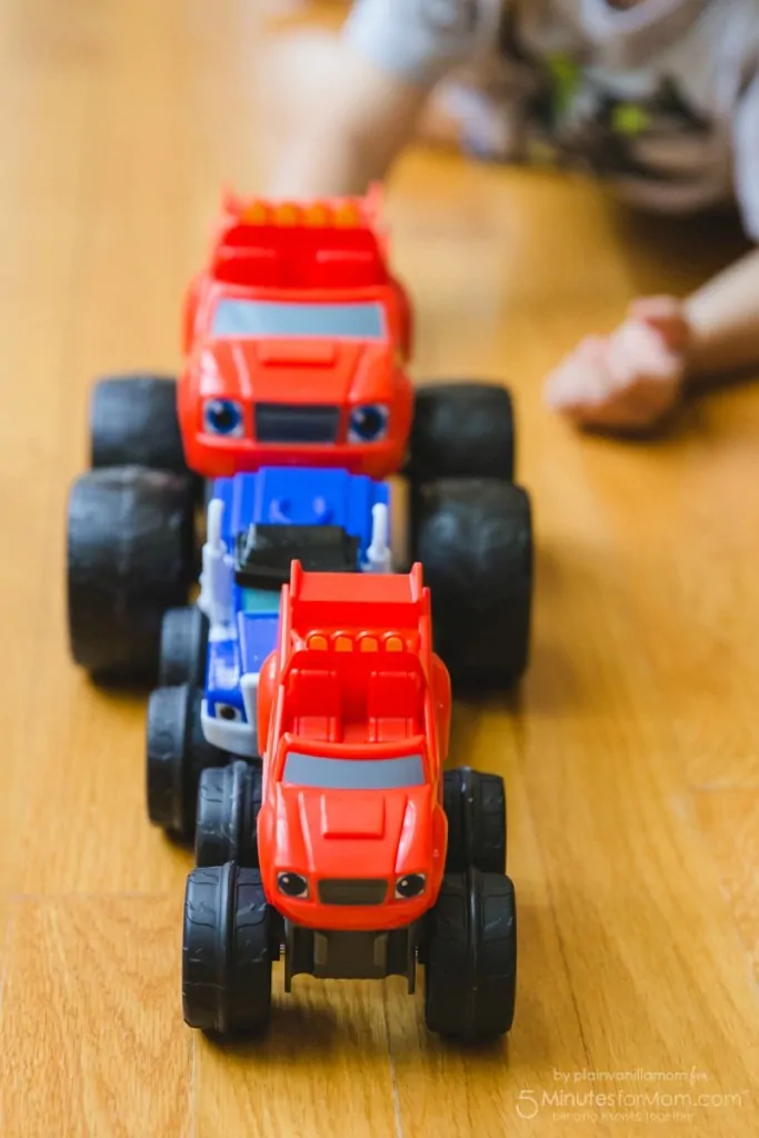 Blaze Playdate child playing with three trucks