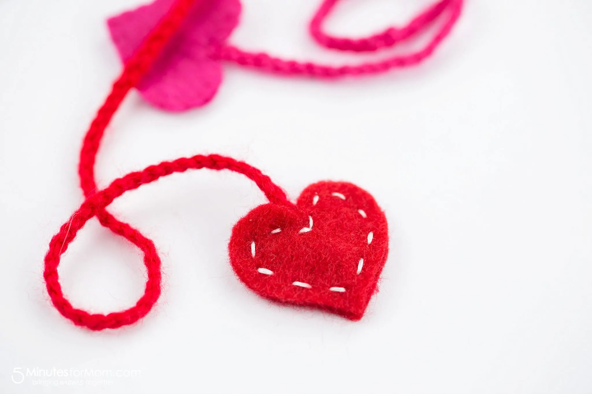 close up photo of a red felt heart on the end of a bookmark