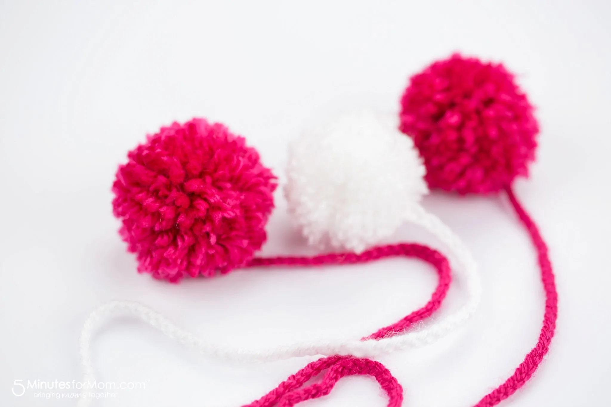 pink and white yarn pom poms