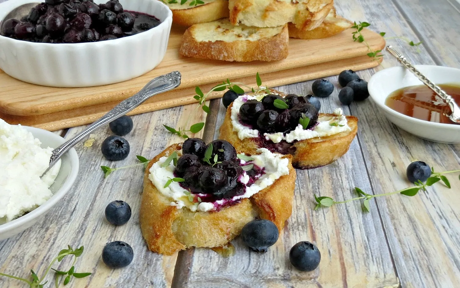 Two slices of Blueberry Goat Cheese Crostini with Thyme Honey