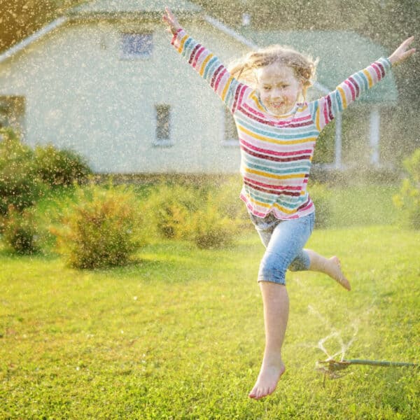 Summer Fun Running Through a Sprinkler