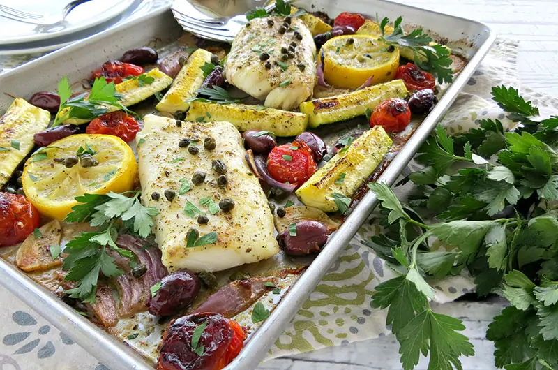 Mediterranean Cod Sheet Pan Dinner. Thinly slicing the garlic and quartering the zucchini ensures that they cook through in the same time as the fish.