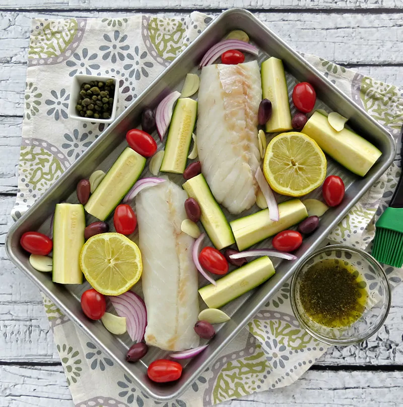 Mediterranean Cod Sheet Pan Dinner. Thinly slicing the garlic and quartering the zucchini ensures that they cook through in the same time as the fish.