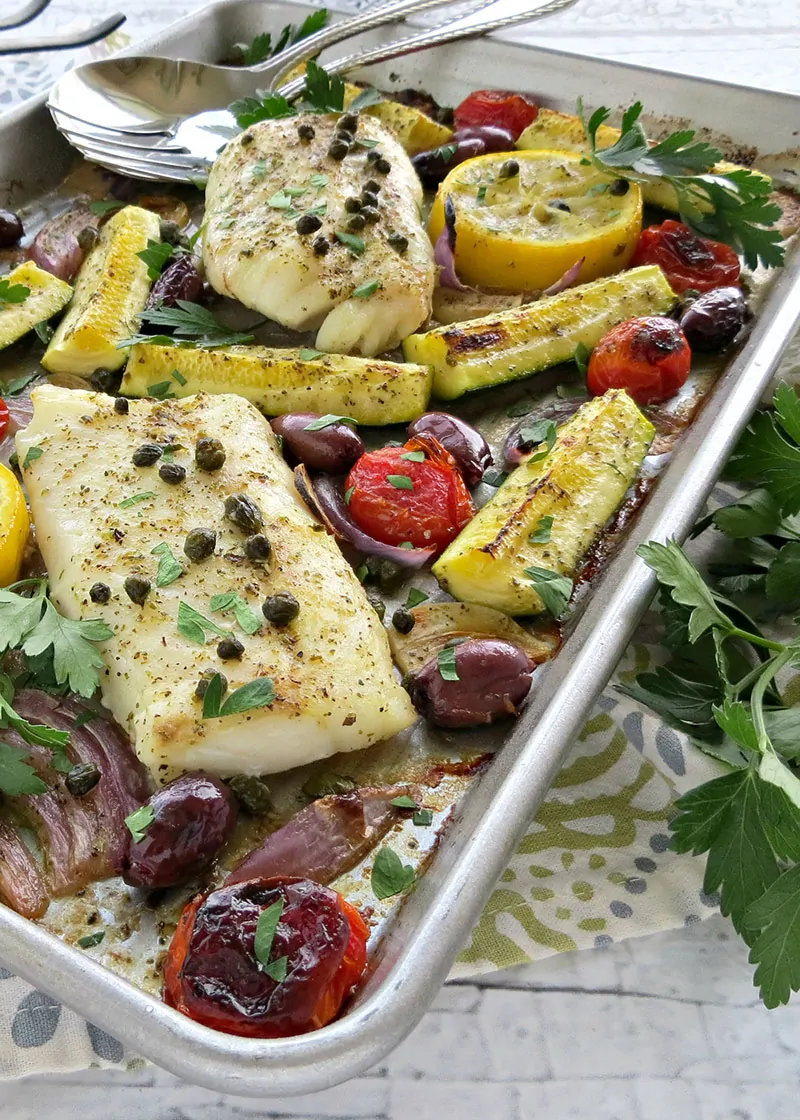 Mediterranean Cod Sheet Pan Dinner. Thinly slicing the garlic and quartering the zucchini ensures that they cook through in the same time as the fish.