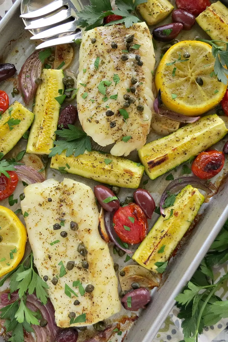 Mediterranean Cod Sheet Pan Dinner. Thinly slicing the garlic and quartering the zucchini ensures that they cook through in the same time as the fish.