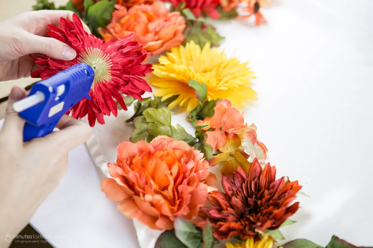 Using a glue gun to attach the flowers to the dress