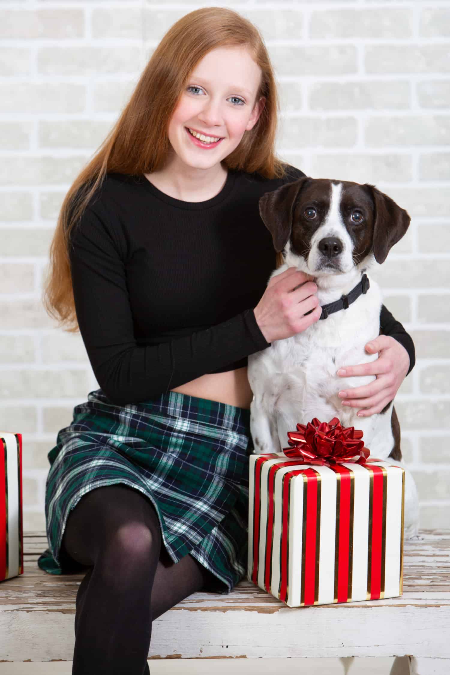Teen girl giving a Christmas gift to her dog