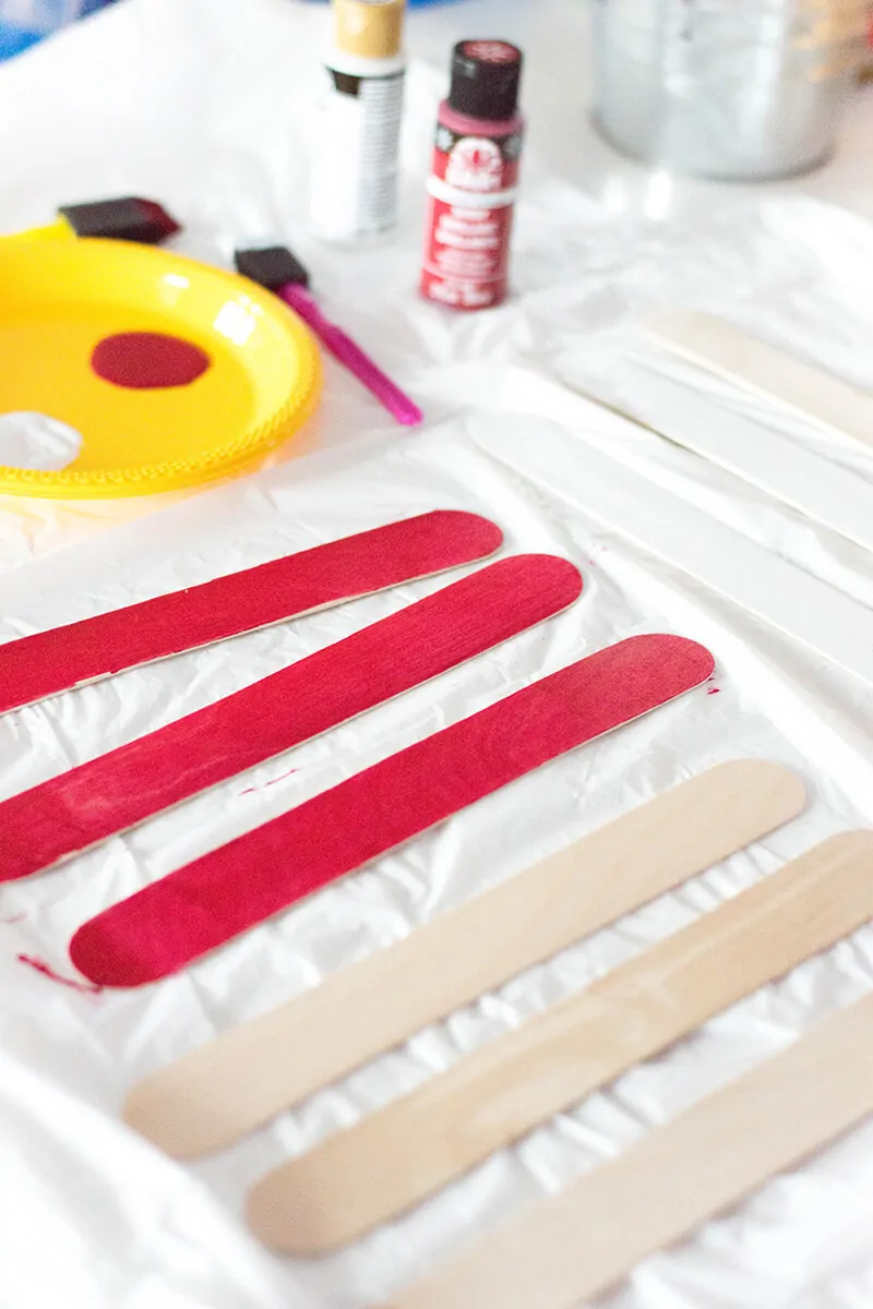 Painting craft sticks red.