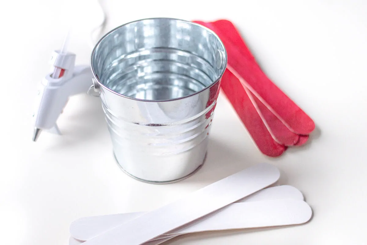 Painted craft sticks and metal pot.