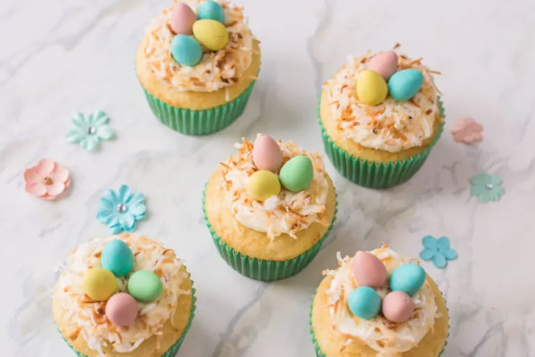 Vanilla cupcakes topped with buttercream, shredded coconut and candied eggs: they make for the perfect Bird's Nest Cupcakes!