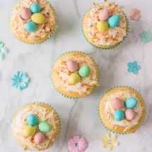 Vanilla cupcakes topped with buttercream, shredded coconut and candied eggs: they make for the perfect Bird's Nest Cupcakes!