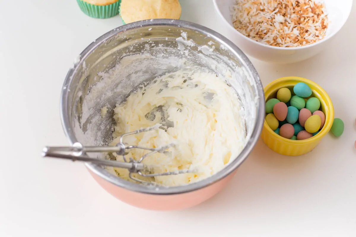 Vanilla cupcakes topped with buttercream, shredded coconut and candied eggs: they make for the perfect Bird's Nest Cupcakes!