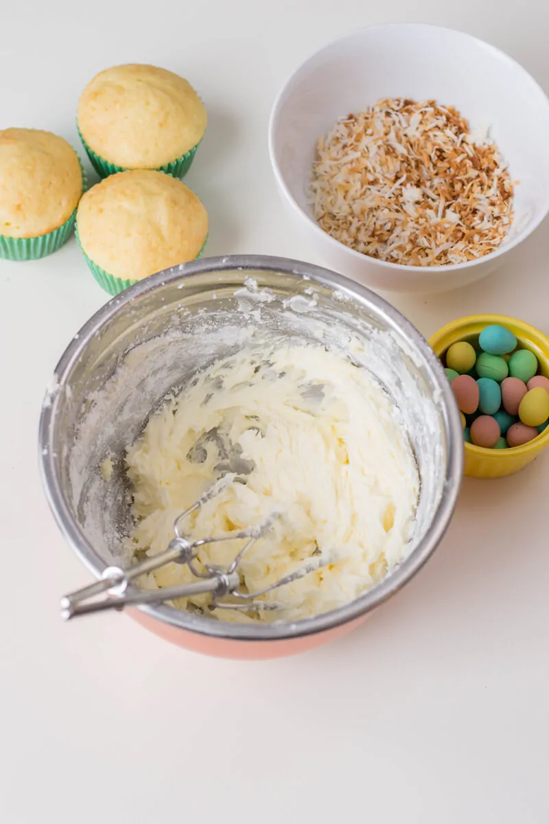 Vanilla cupcakes topped with buttercream, shredded coconut and candied eggs: they make for the perfect Bird's Nest Cupcakes!