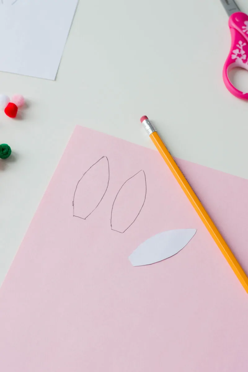 Cutting out paper ears to make a Bunny Pencil Holder.