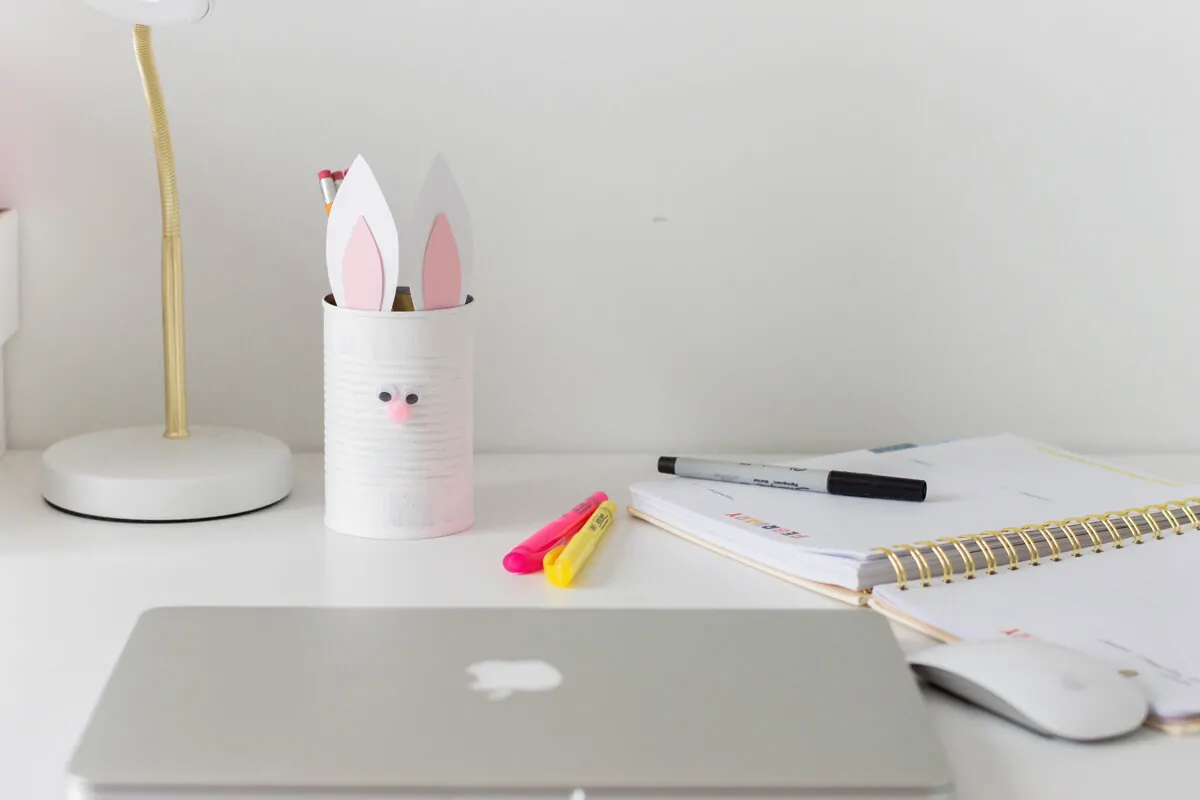 Easter Craft for Kids - Bunny Pencil Holder made of a painted tin can with bunny ears and a pompom nose.