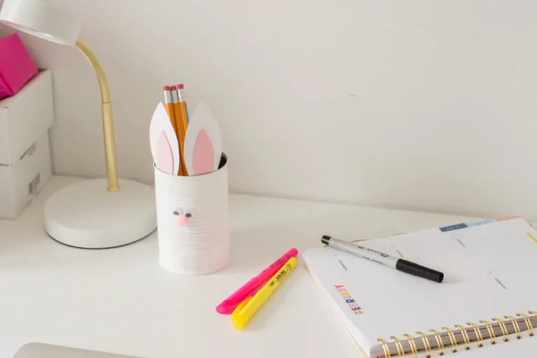 An Easter DIY made of a painted tin can with bunny ears and a pompom nose. Here's our very own Bunny Pencil Holder.