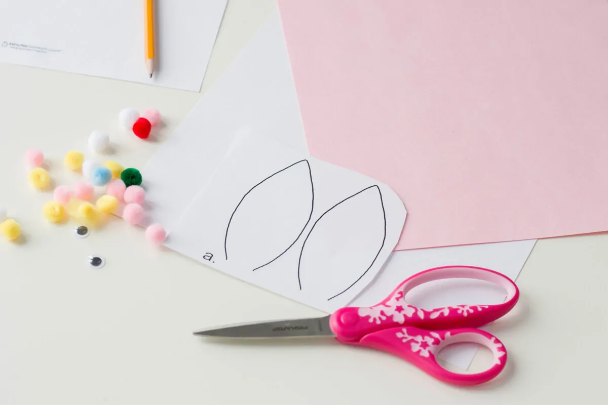 Cutting out paper ears to make a Bunny Pencil Holder.