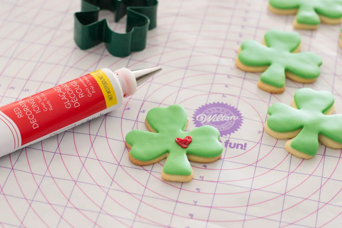 St. Patrick's Day Sugar Cookies shaped as lucky clovers with green fondant and a frosted heart.