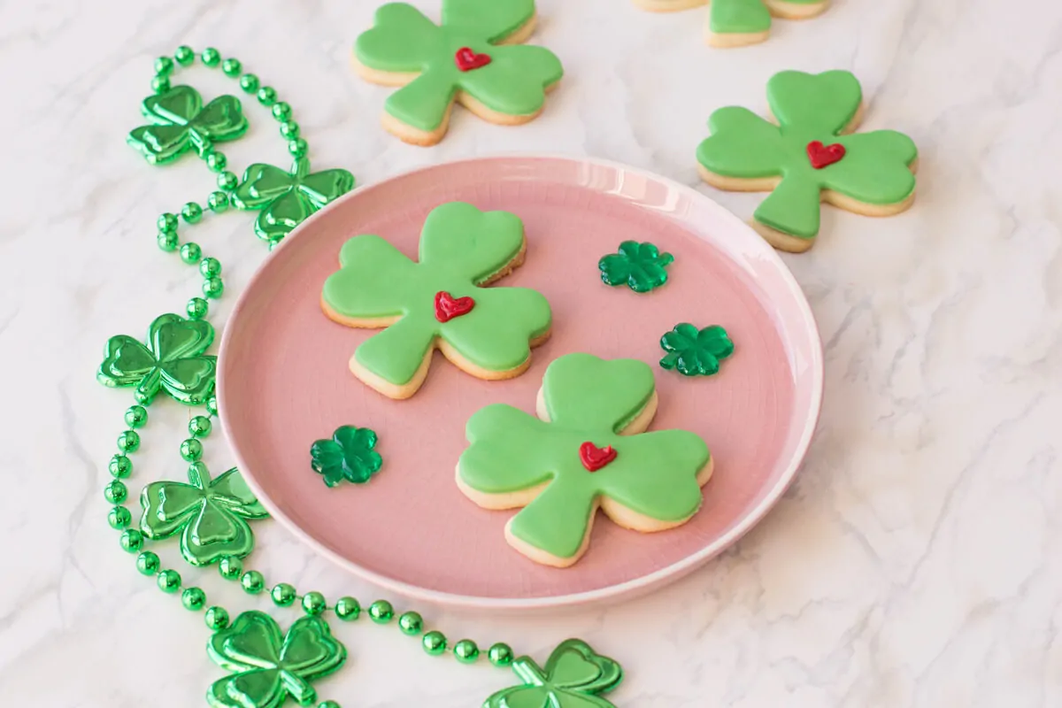 St. Patrick's Day Sugar Cookies shaped as lucky clovers with green fondant and a frosted heart.