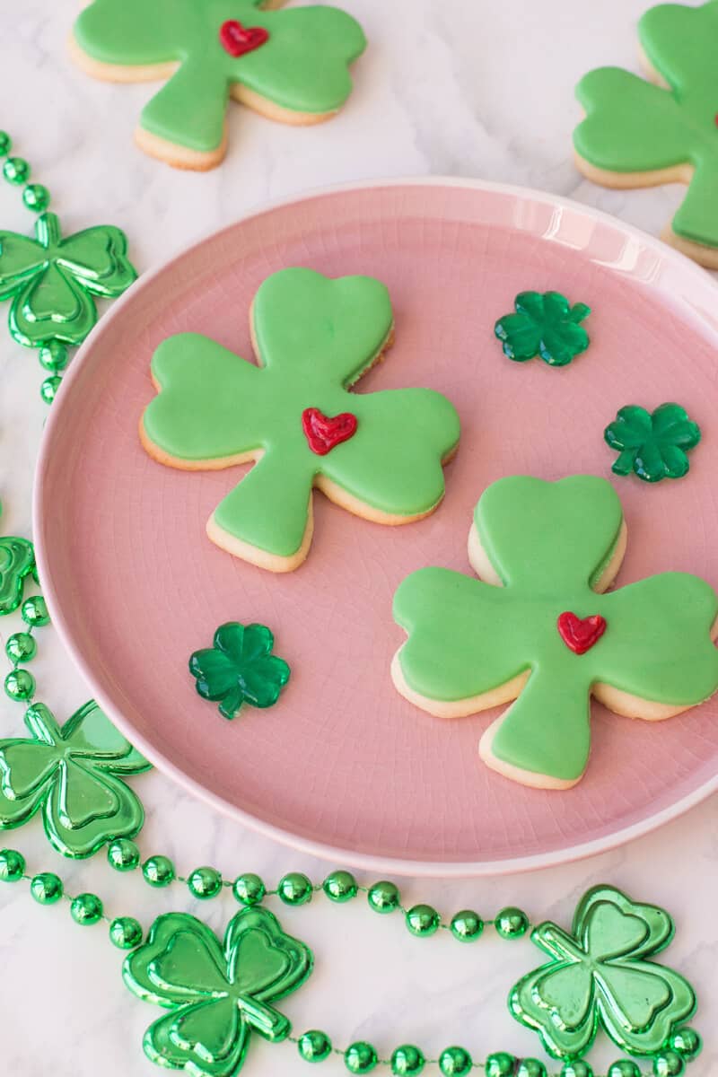 St Patricks Day Sugar Cookies shaped as lucky clovers with green fondant and a frosted heart.