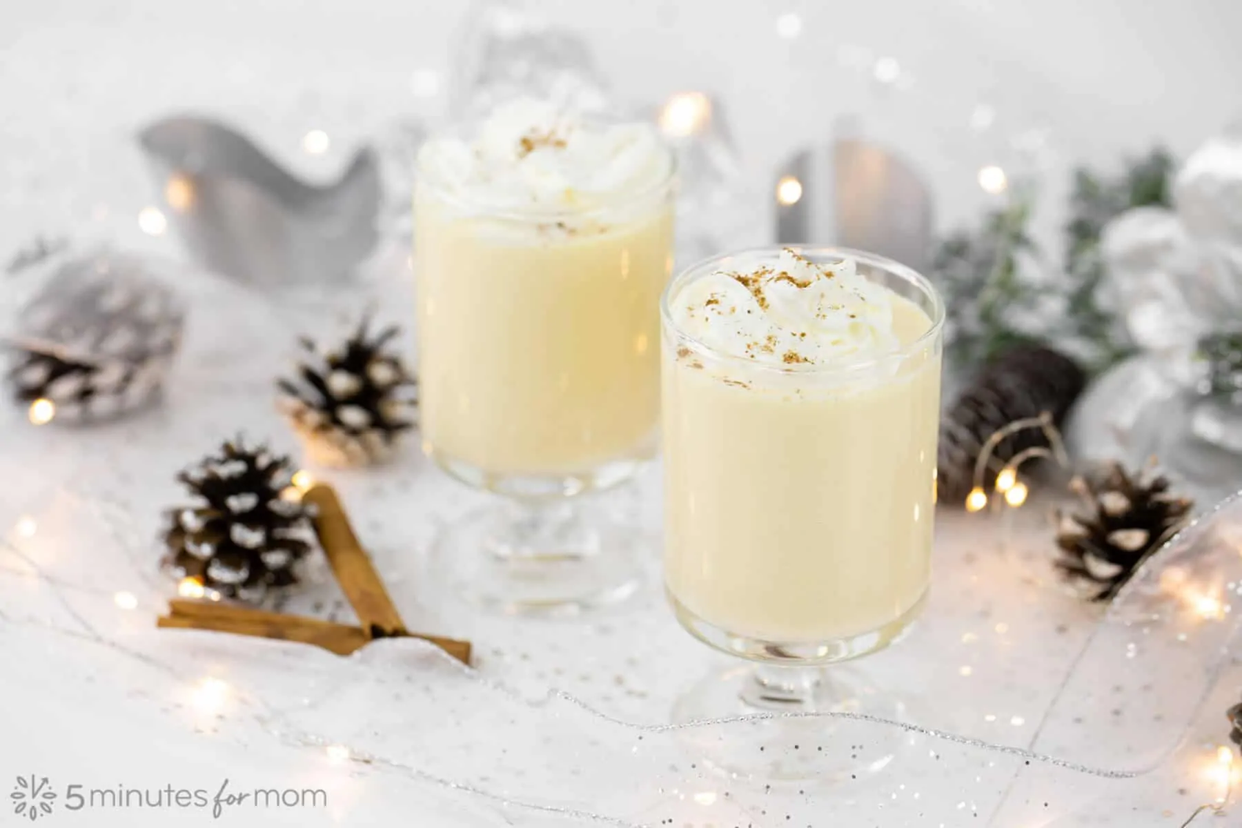 Two glasses of Homemade Eggnog on holiday decorated table to show results of How to Make Eggnog