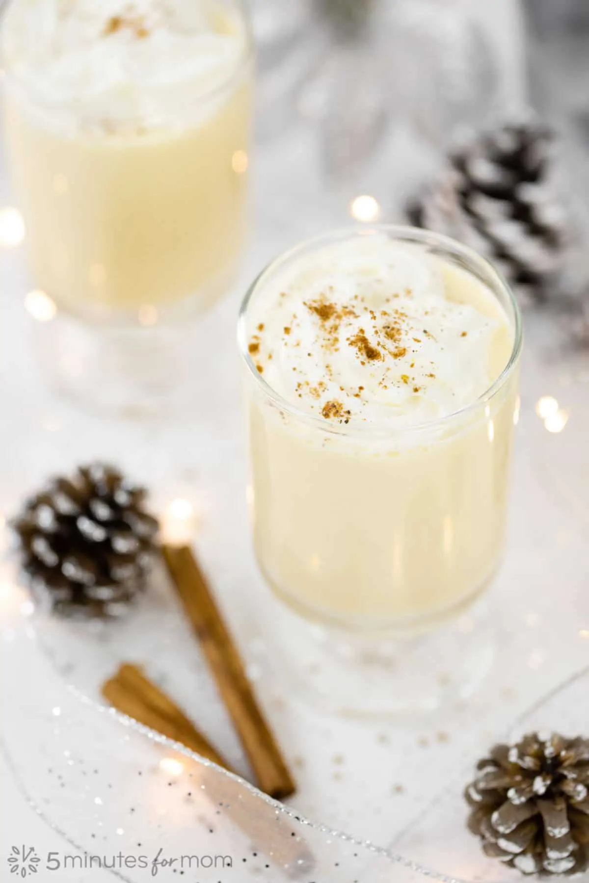 Cooked eggnog topped with whipped cream and cinnamon sprinkles