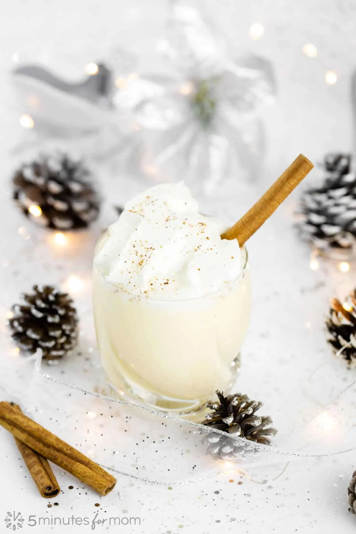 Glass of cooked homemade eggnog topped with whipped cream and cinnamon.