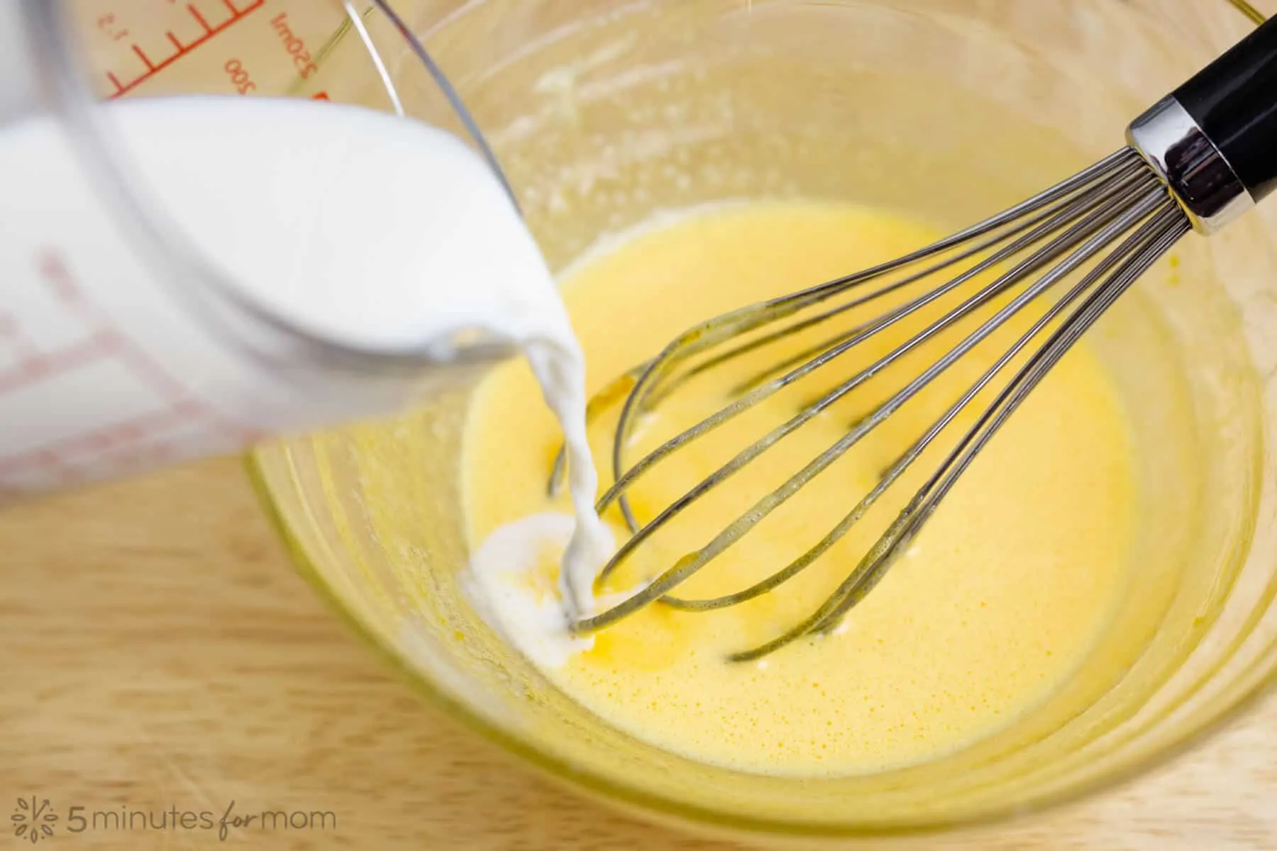 showing how to temper eggs by slowly adding hot milk to beaten eggs