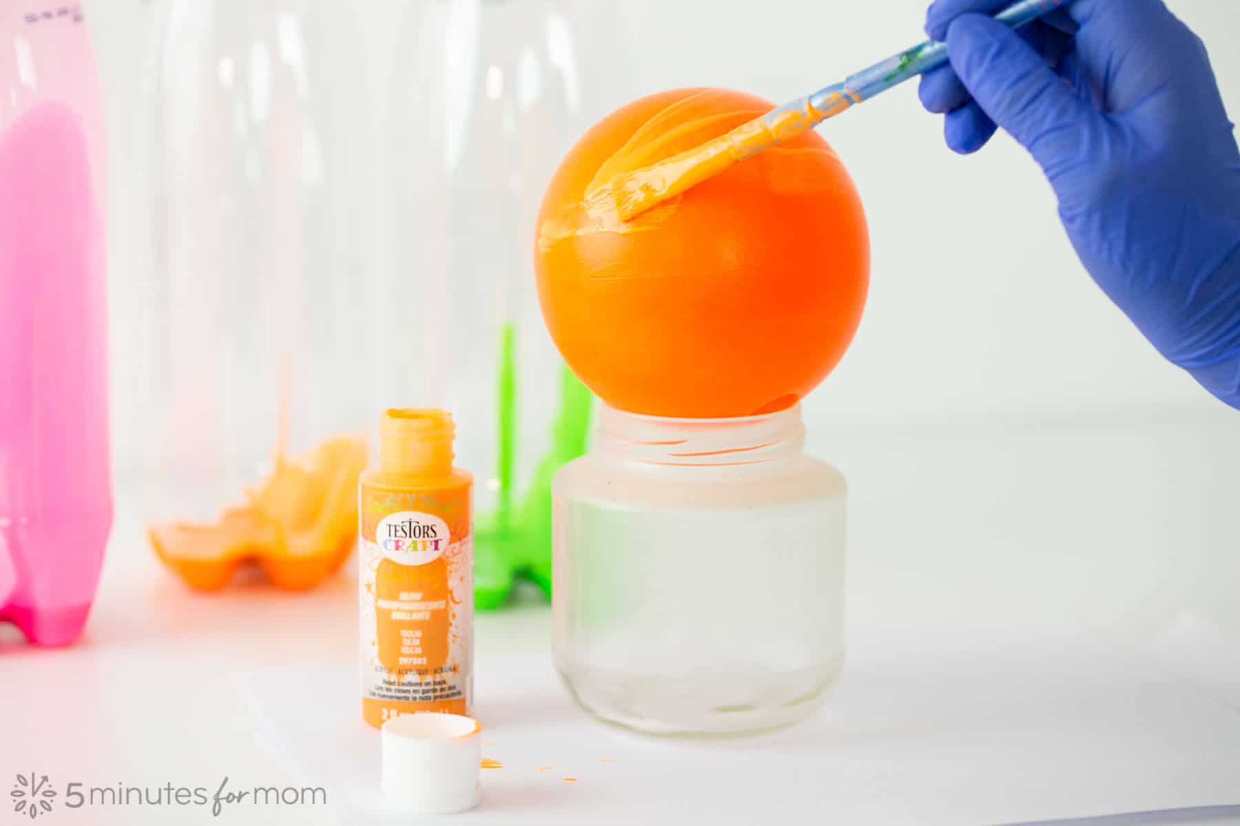 Paint plastic balls with Testors Craft Acrylic Glow Paint