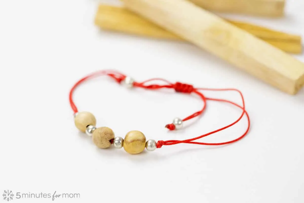 Bracelet made of Palo Santo Beads with Palo Santo Sticks In the background