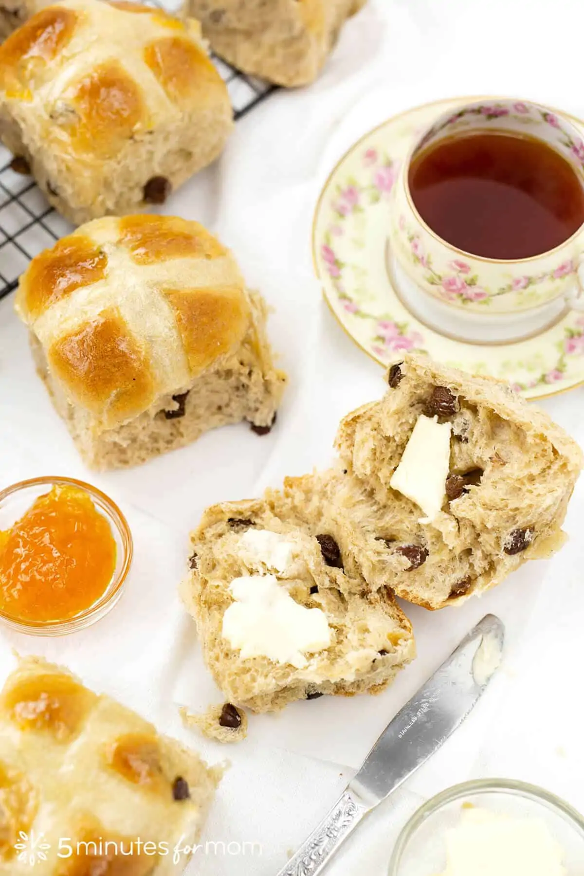 traditional hot cross buns served with butter and a cup of tea