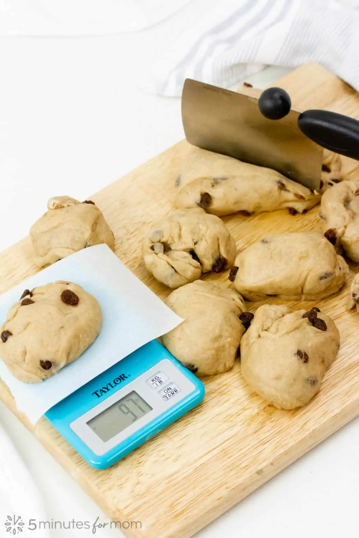 divide the dough in twelve and measure each portion with a kitchen scale for evenly baked buns