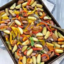 baking sheet with oven roasted potatoes, peppers and onions with fresh basil