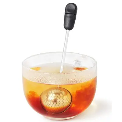 Tea Infuser resting inside of a glass cup of tea for an inexpensive gift idea