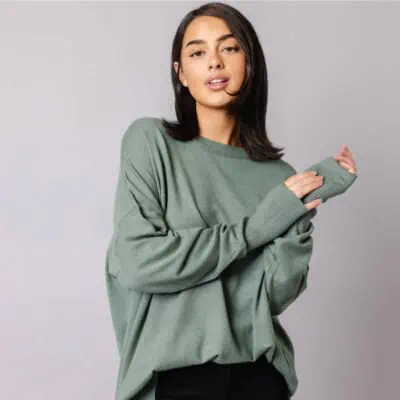 A women wearing a pretty light green sweater to show how a perfect Christmas gift for women is a cozy sweater