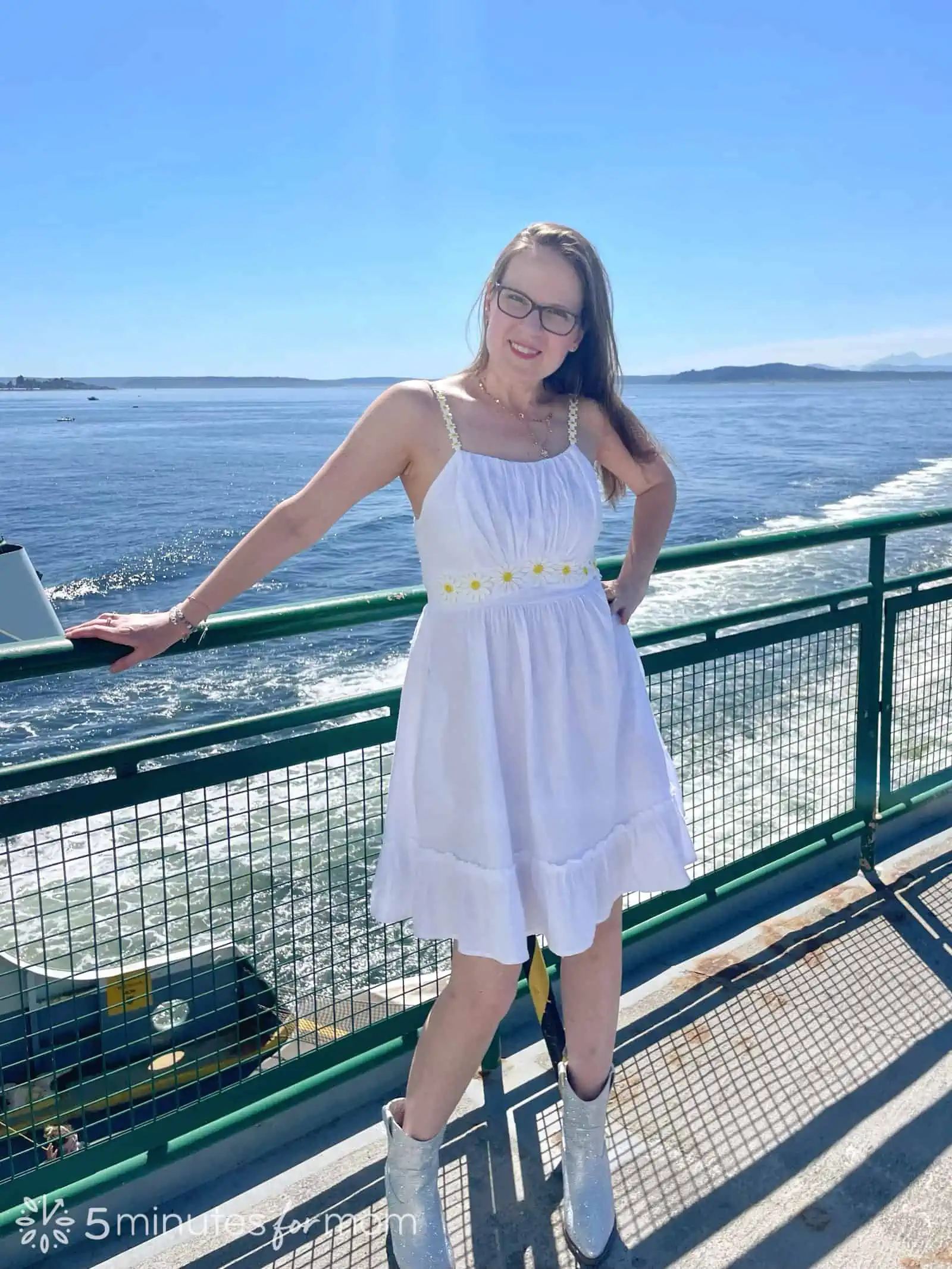 Mother dressed  in a daisy trimmed white sundress with rhinestone cowboy boots for Taylor Swift Eras Tour